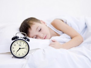 Little boy sleeping with alarm clock